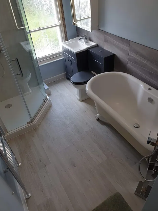 Bathroom with freestanding bath, shower enclosure and fitted basin unit