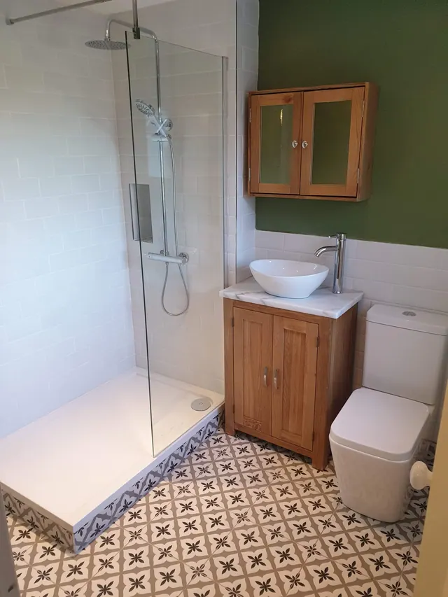 Completed bathroom with oak furniture, patterned floor and walk-in shower